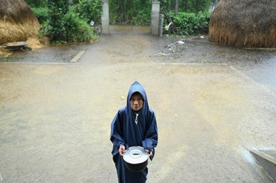Hình minh hoạ. Một phụ nữ lớn tuổi cầm bát cơm cạnh căn nhà ngập nước của bà ở Hải Lăng, tỉnh Quảng Trị hôm 16/10/2020